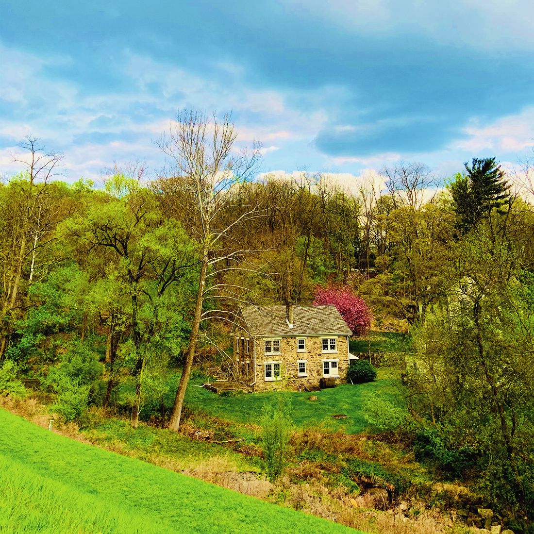 Stone farmhouse in a green spring valley